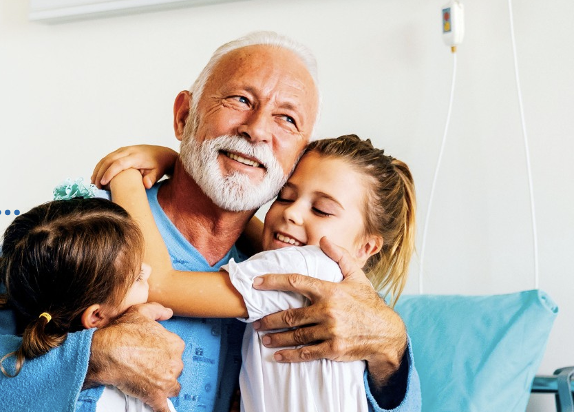 Elderly man spending time with two young children